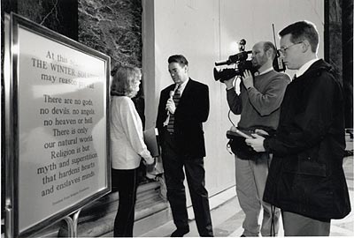 Anne Gaylor being interviewed by press by the Winter Solstice sign. Photo: Brent Nicastro