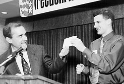 Foundation staff member Dan Barker handing college awardee Adam Butler a check